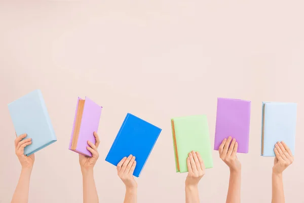 Vrouwelijke handen met boeken over kleur achtergrond — Stockfoto