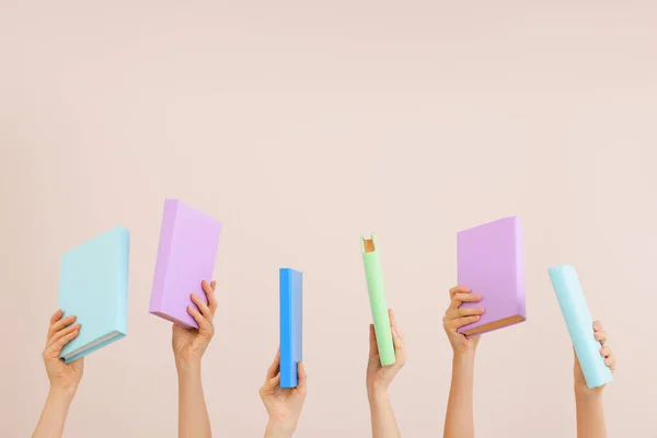 Mãos femininas com livros sobre fundo de cor — Fotografia de Stock