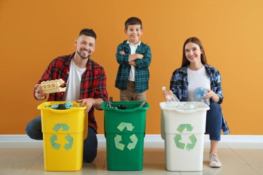 Renkli arka planda çöp konteynırları olan bir aile. Geri dönüşüm kavramı