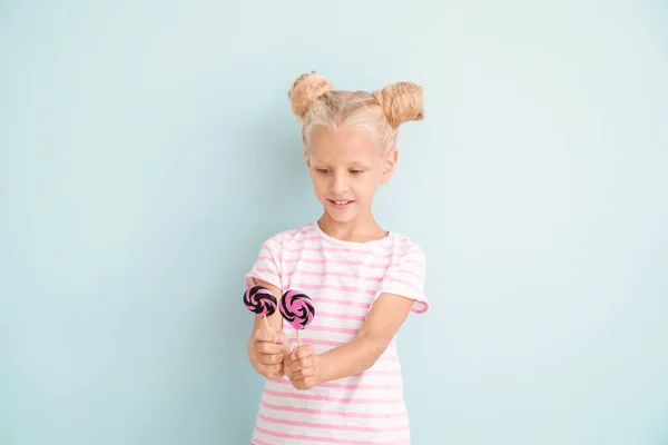Lolipop renk arka plan üzerinde ile sevimli küçük kız — Stok fotoğraf