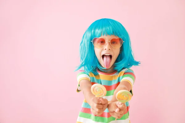 Cute little girl in bright wig and with lollipops on color background — Stock Photo, Image