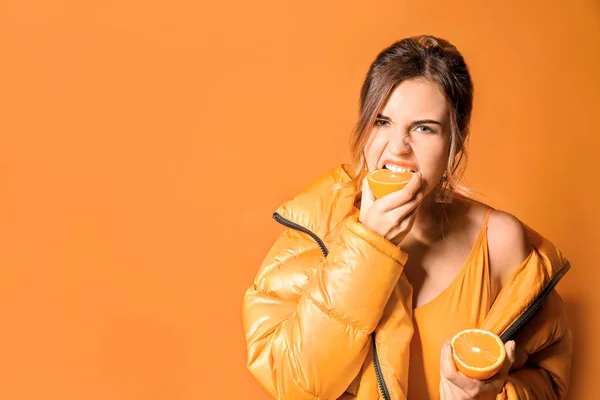 Fashionable young woman with lemon on color background — Stock Photo, Image