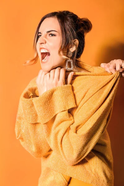 Aggressive fashionable young woman on color background