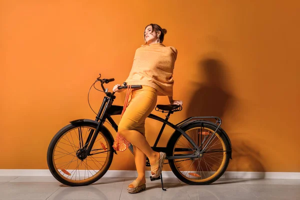 Fashionable young woman with bicycle near color wall — Stock Photo, Image