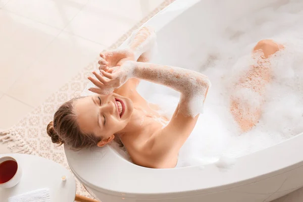 Belle jeune femme prenant un bain à la maison — Photo