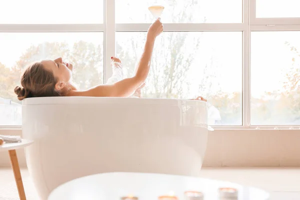 Gyönyörű fiatal nő iszik koktélt fürdés közben — Stock Fotó