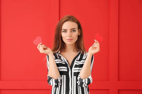 Vacker ung kvinna med små röda hjärtan på färg bakgrund — Stockfoto