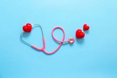 Stetoskop ve arka planda kırmızı kalpler. Kardiyoloji kavramı