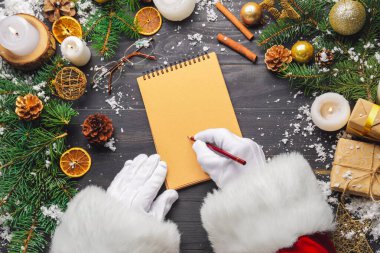 Noel Baba deftere bir şeyler yazıyor.