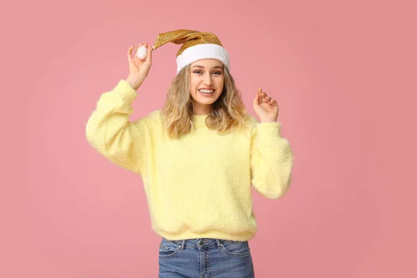 Ευτυχισμένη νεαρή γυναίκα σε χειμωνιάτικα ρούχα και ο Άγιος Βασίλης καπέλο στο φόντο χρώμα — Φωτογραφία Αρχείου