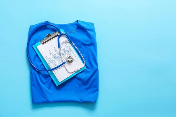 Stetoscopio, uniforme del medico e documenti su sfondo a colori. Concetto di cardiologia — Foto Stock