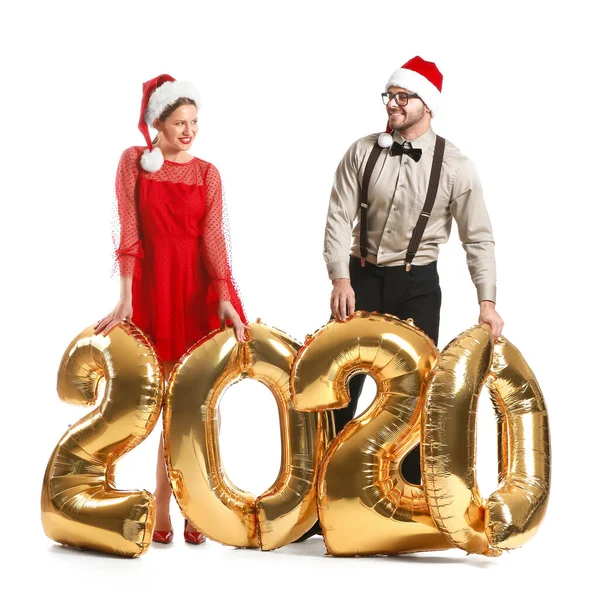 Gelukkig paar in Santa Claus hoeden en met luchtballonnen op witte achtergrond — Stockfoto