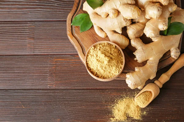 Fresh and ground ginger on wooden table — Stock Photo, Image