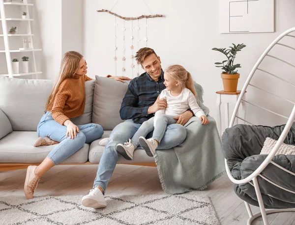 Feliz jovem família sentada no sofá em casa — Fotografia de Stock