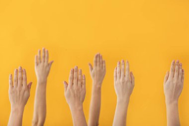 Renkli arka planda oy kullananların elleri