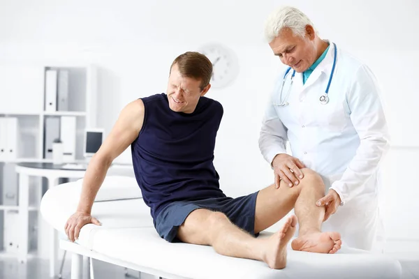 Arzt untersucht Sportler mit Gelenkschmerzen in Klinik — Stockfoto