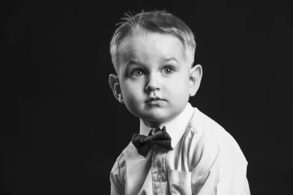 Retrato preto e branco de menino elegante no fundo escuro — Fotografia de Stock