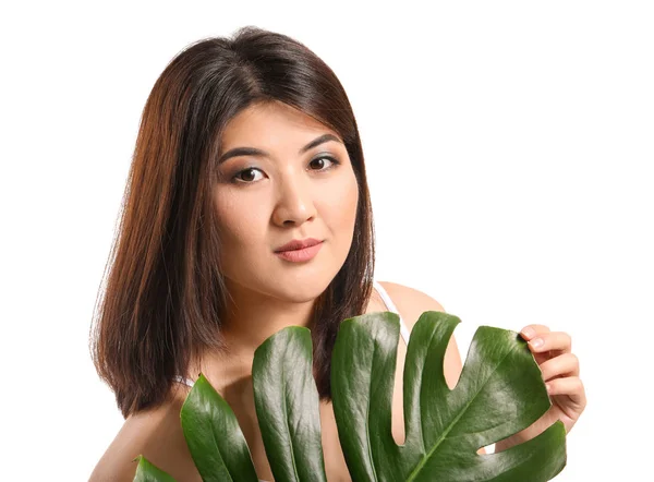 Portrait of young Asian woman with tropical leaf on white background — Stock Photo, Image