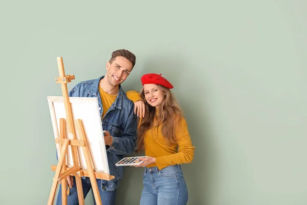 Couple of young artists on color background — Stock Photo, Image