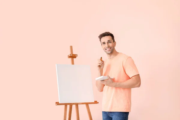 Young male artist on color background — Stock Photo, Image