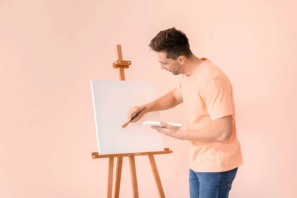 Ung manlig konstnär på färg bakgrund — Stockfoto