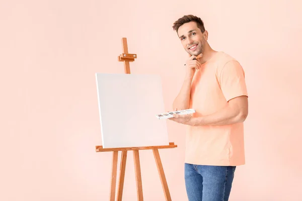 Young male artist on color background — Stock Photo, Image