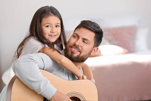 Little daughter and her father playing guitar at home — Stock Photo, Image