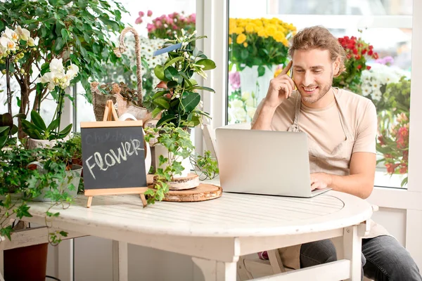 Florist taking order by phone in shop — Stock Photo, Image