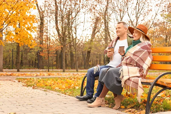 Feliz pareja adulta tomando café en el parque de otoño —  Fotos de Stock