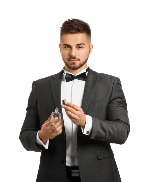 Joven guapo con botella de perfume sobre fondo blanco —  Fotos de Stock