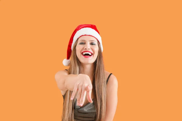Hermosa mujer joven en sombrero de Santa sobre fondo de color — Foto de Stock