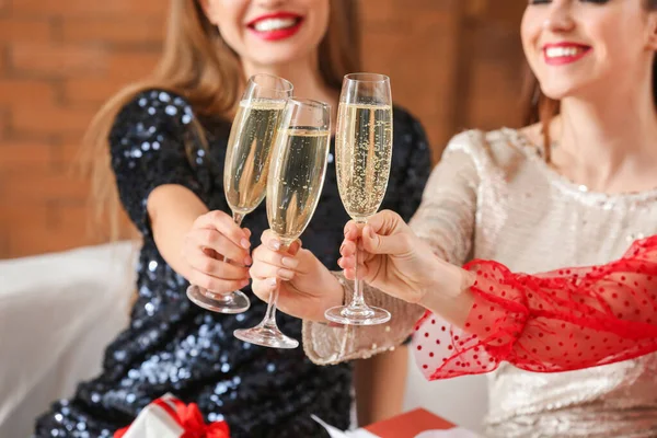 Beautiful young women drinking champagne at home on Christmas eve — Stock Photo, Image