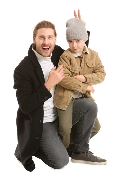 Красивый мужчина и его маленький сын в зимней одежде на белом фоне — стоковое фото