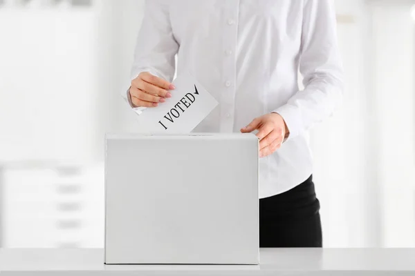 Głosująca kobieta w pobliżu urny wyborczej w pomieszczeniach — Zdjęcie stockowe