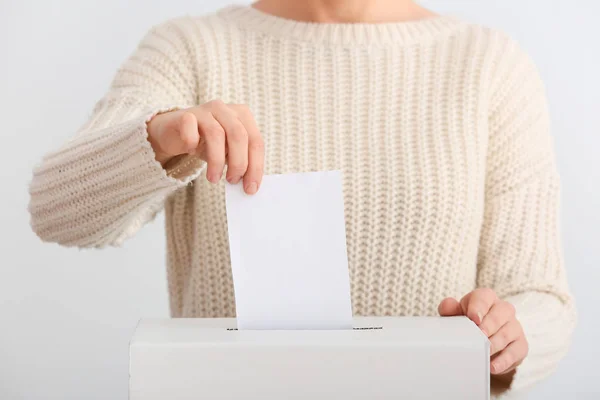 Голосування жінки біля коробки для голосування на світлому фоні — стокове фото