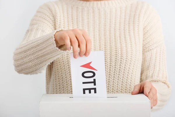 Głosująca kobieta w pobliżu urny do głosowania na jasnym tle — Zdjęcie stockowe