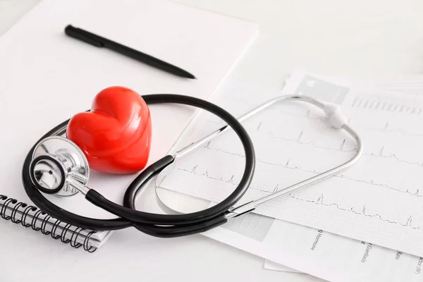 听诊器，心动图和心脏在医生的桌子上。 心脏科概念 — 图库照片