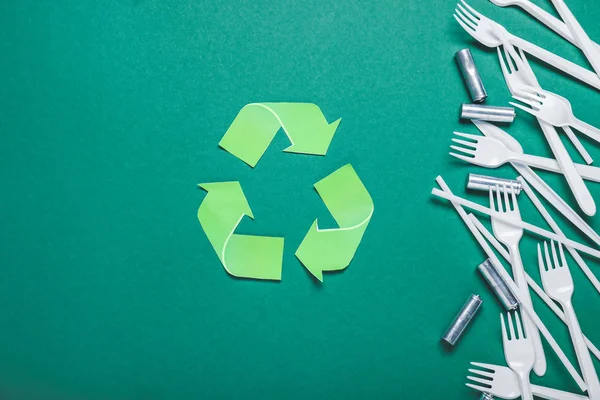 Horquillas de plástico, pajitas y baterías sobre fondo de color. Concepto de reciclaje —  Fotos de Stock