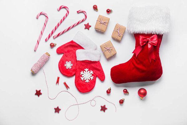 Christmas sock with gifts and mittens on white background