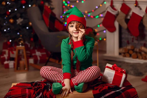 Bambina in costume da elfo, con regalo e biscotto in camera decorato per Natale — Foto Stock