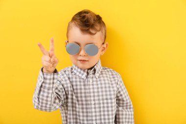 Renkli arka planda zafer jesti gösteren sevimli küçük bir çocuk portresi