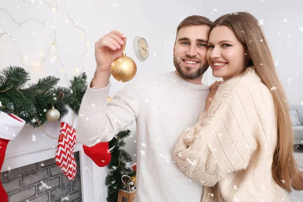 Feliz joven pareja descansando en casa en Nochebuena — Foto de Stock