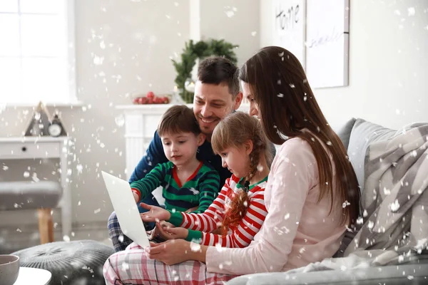 Lycklig familj med bärbar dator vilar hemma på julafton — Stockfoto