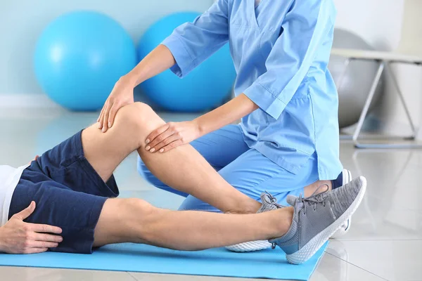 Fisioterapista che lavora con un paziente di sesso maschile nel centro di riabilitazione — Foto Stock