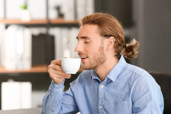 Schöner Geschäftsmann, der Kaffee im Büro trinkt — Stockfoto