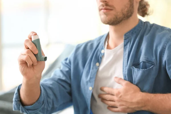 Hombre enfermo con inhalador de asma en casa, primer plano — Foto de Stock