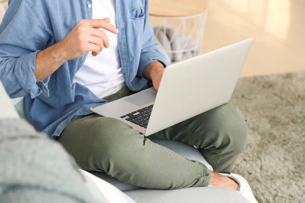 Όμορφος άντρας με laptop στον καναπέ στο σπίτι — Φωτογραφία Αρχείου