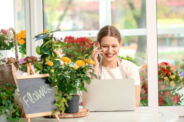 Florist taking order by phone in shop — Stock Photo, Image