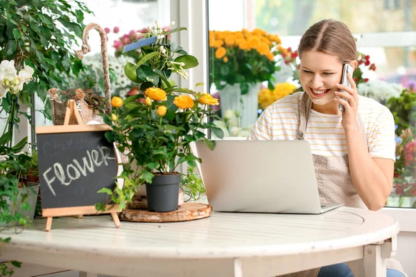 Florist taking order by phone in shop — Stock Photo, Image