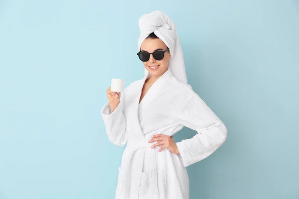 Beautiful young woman after shower drinking coffee on color background — Stockfoto